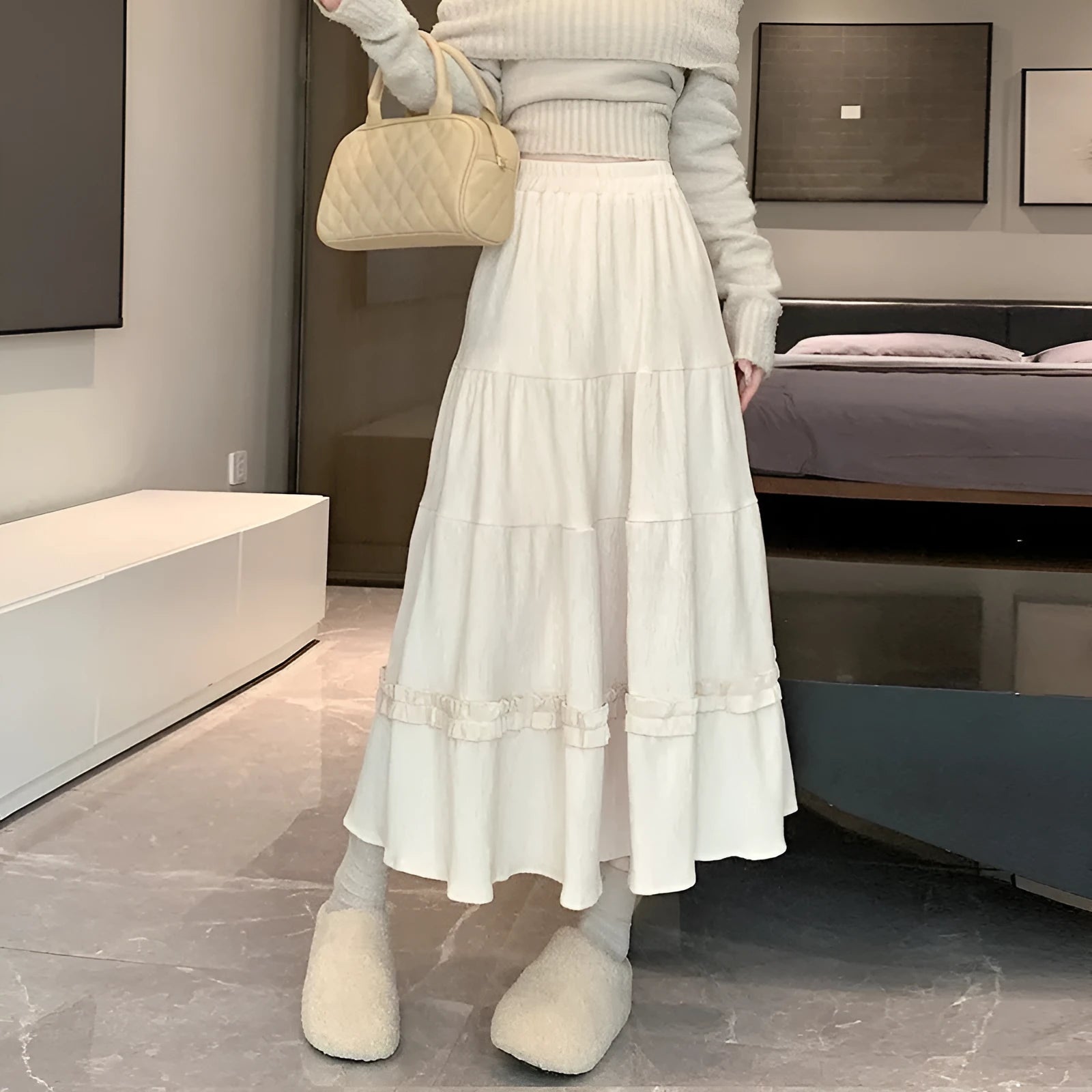 Beige corduroy A-line midi skirt with elastic waistband on a hanger.