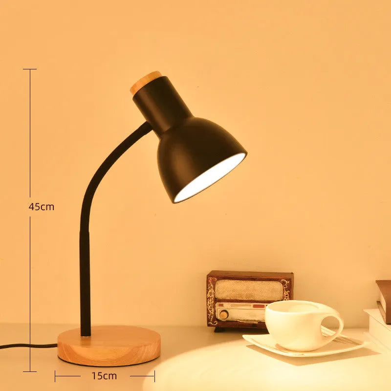 A simple modern Nordic style LED desk lamp with a dimmer switch on a desk.