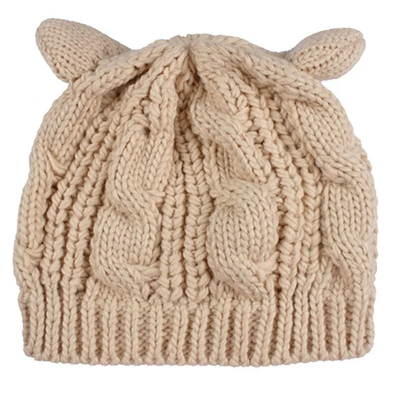 Hand knitted red wool beanie with 3D cat ears on a white background