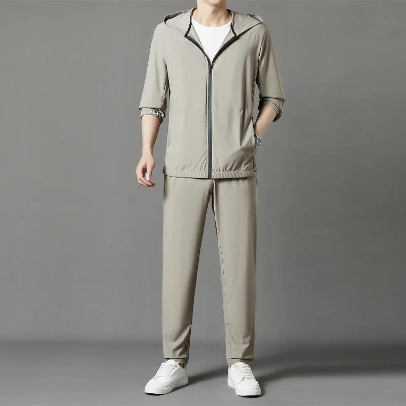 Grey loose-fit hooded sun-protective jacket and trousers set on a hanger