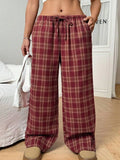 Red plaid women's casual trousers with a drawstring waist and pockets on a hanger.