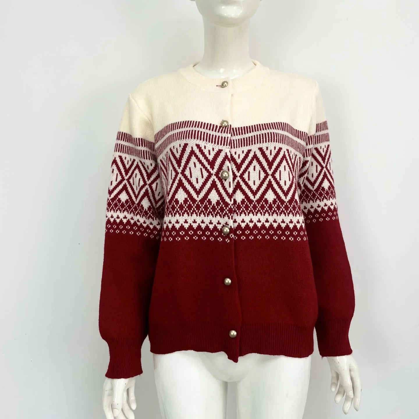 Woman wearing a grey alpaca wool cardigan with a long-sleeve diamond knit pattern in contrasting colours.