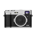 Black dual-lens digital camera with optical viewfinder and 2.88-inch screen on a strap.
