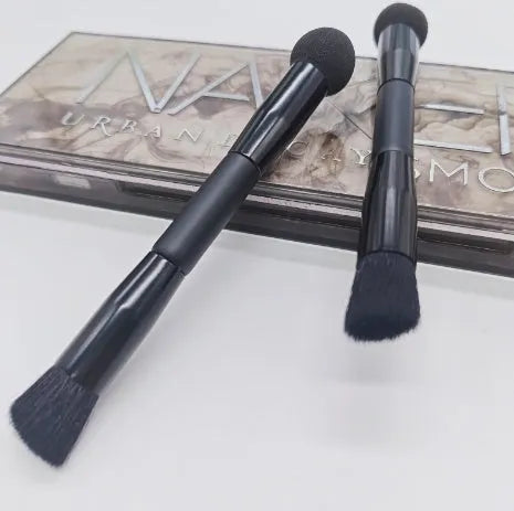 Double-headed concealer brush with black wooden handle, artificial fibre bristles, and angled sponge tip.