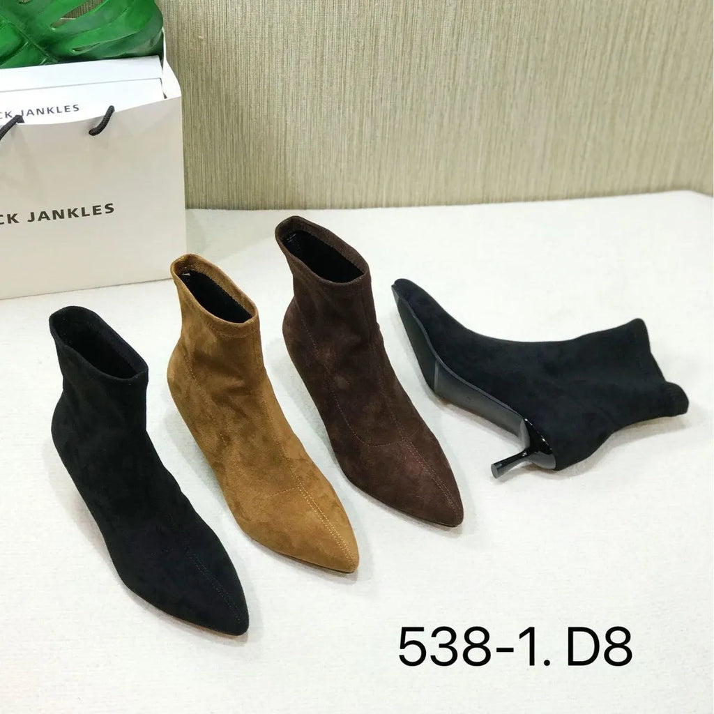 Black women's pointed toe ankle boots with a stiletto heel, shown on a foot.
