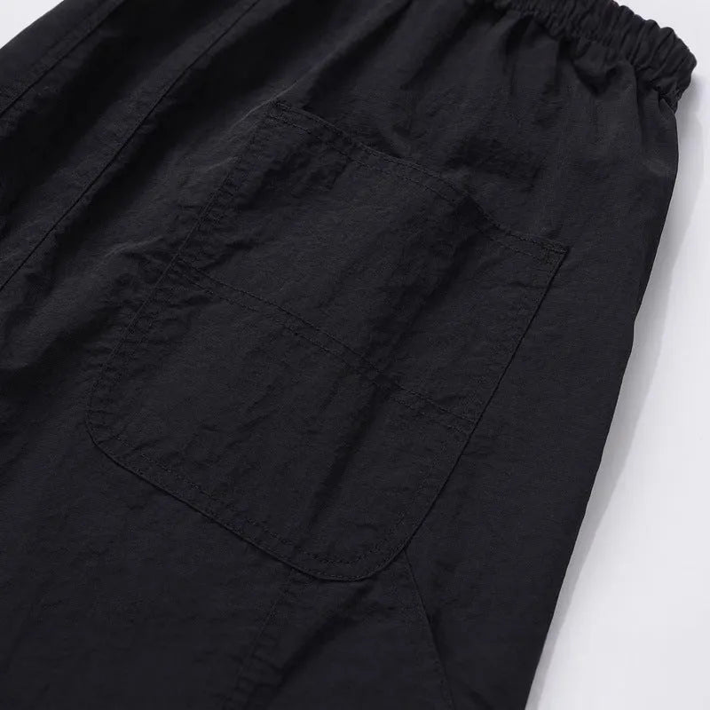 Black paratrooper pants with baggy fit and drawstring waist adjustment