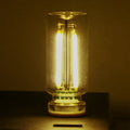Small transparent glass USB touch night lamp with warm white light on a desk