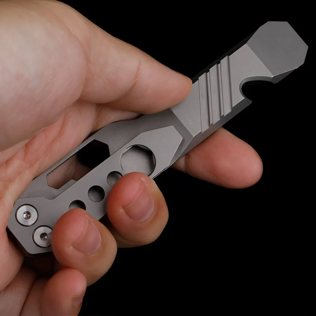 Titanium alloy multi-tool with crowbar edge, screwdriver tip, and bottle opener notches on a stone wash finish background.