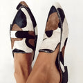 Women's black and white apricot suede pumps with pointed toe, low heel, and animal print.