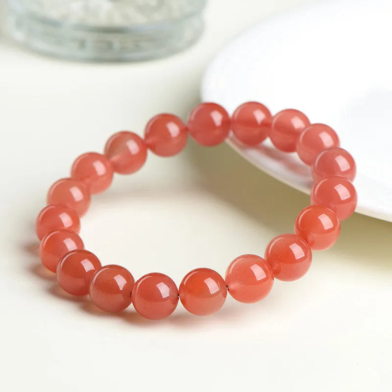 Natural cherry red agate beaded bracelet shown in a single loop, with polished round stones.