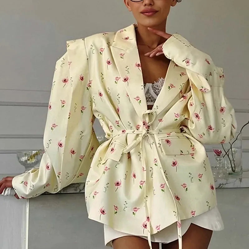A printed suit jacket with a lace-up collar detail and waist-tightening feature on a mannequin.