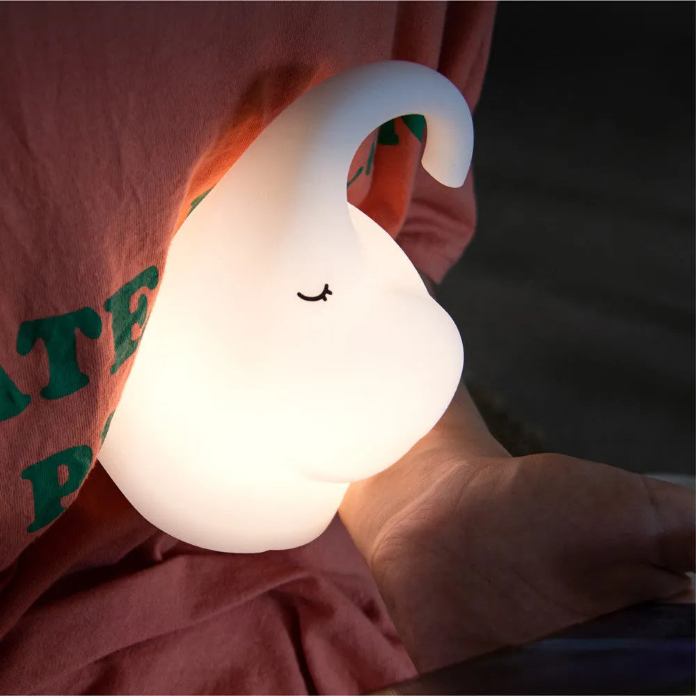 DOMI Elephant shaped silicone night light on a table showing its compact size and soft glow.