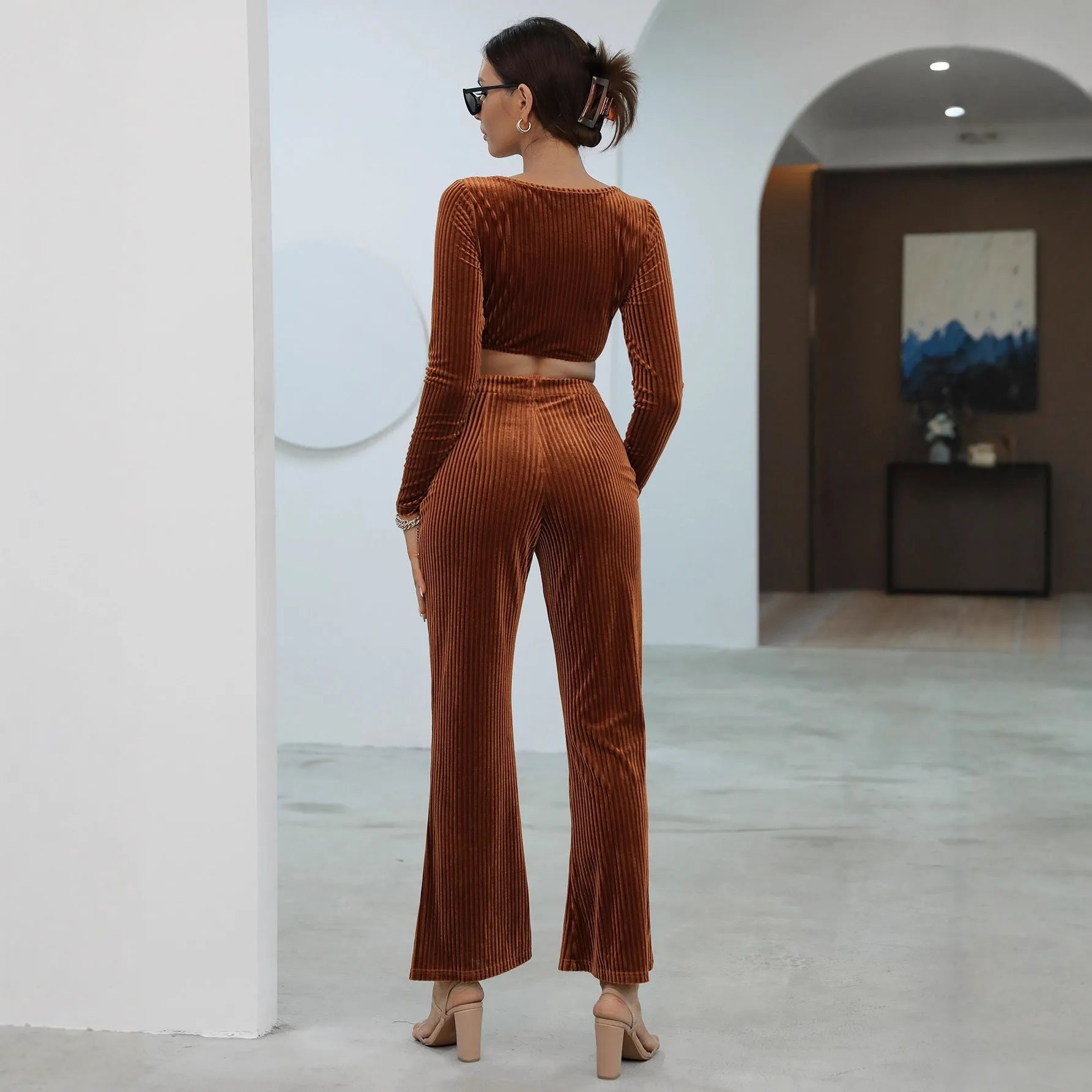 Caramel coloured long sleeve sweater and straight-leg trousers set on a hanger