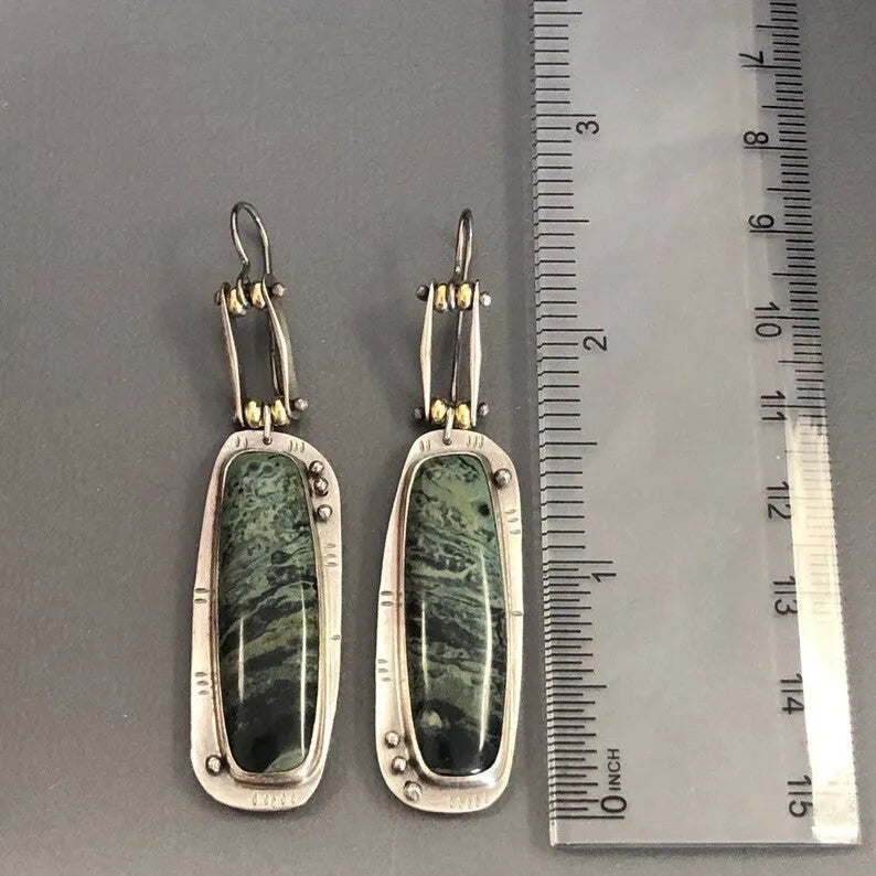 Geometric drop earrings with a white and grey marble pattern on a silver-toned alloy setting.