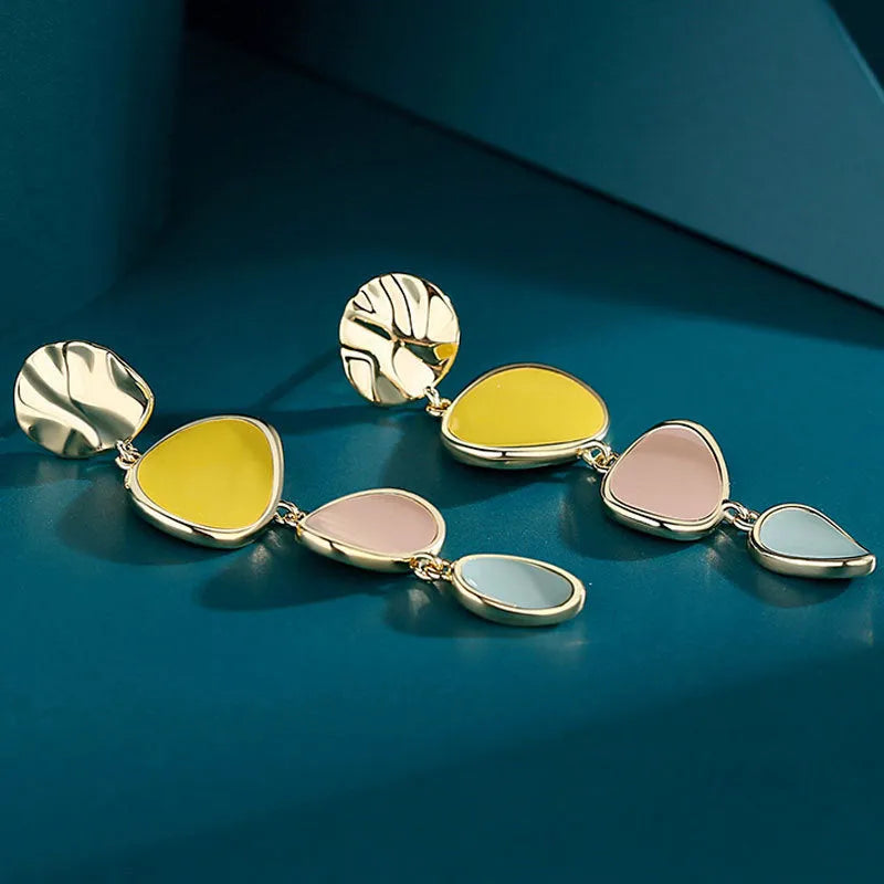 A pair of simple disc-shaped alloy earrings with a Morandi three-colour oil-drip wash finish.