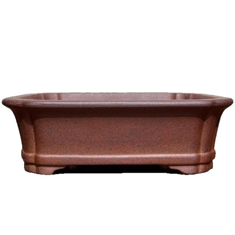 Reddish brown hand-glazed stoneware rectangular bonsai flower pot on a flat surface