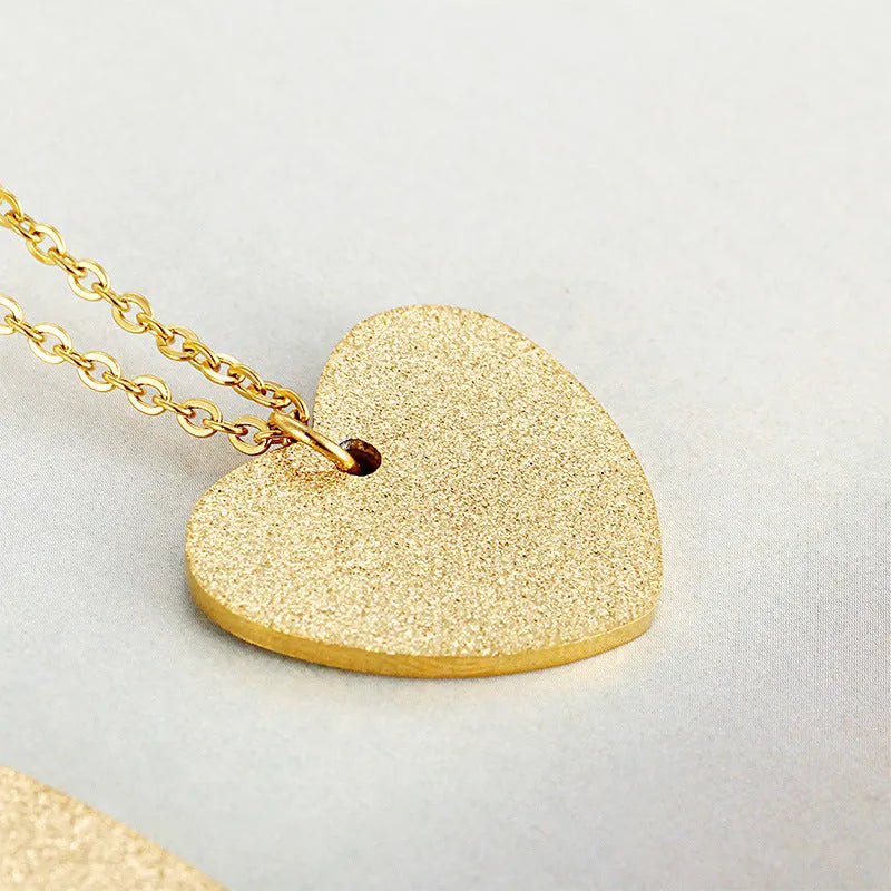 A geometric heart-shaped blue titanium steel pendant necklace on a chain.