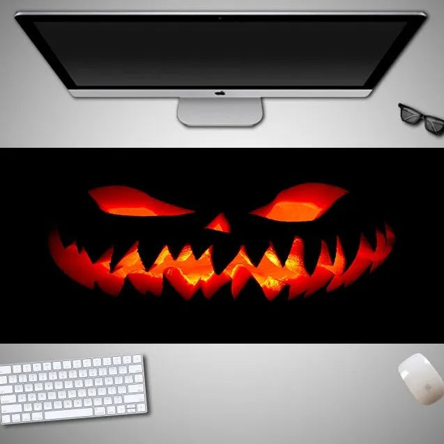 Large Halloween patterned gaming mouse pad on a desk showing non-slip rubber base and extra-long design.