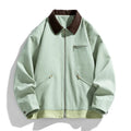 Man wearing a mint green retro-style loose fit jacket with dark contrasting lapels and side seam pockets.