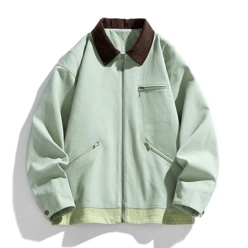 Man wearing a mint green retro-style loose fit jacket with dark contrasting lapels and side seam pockets.