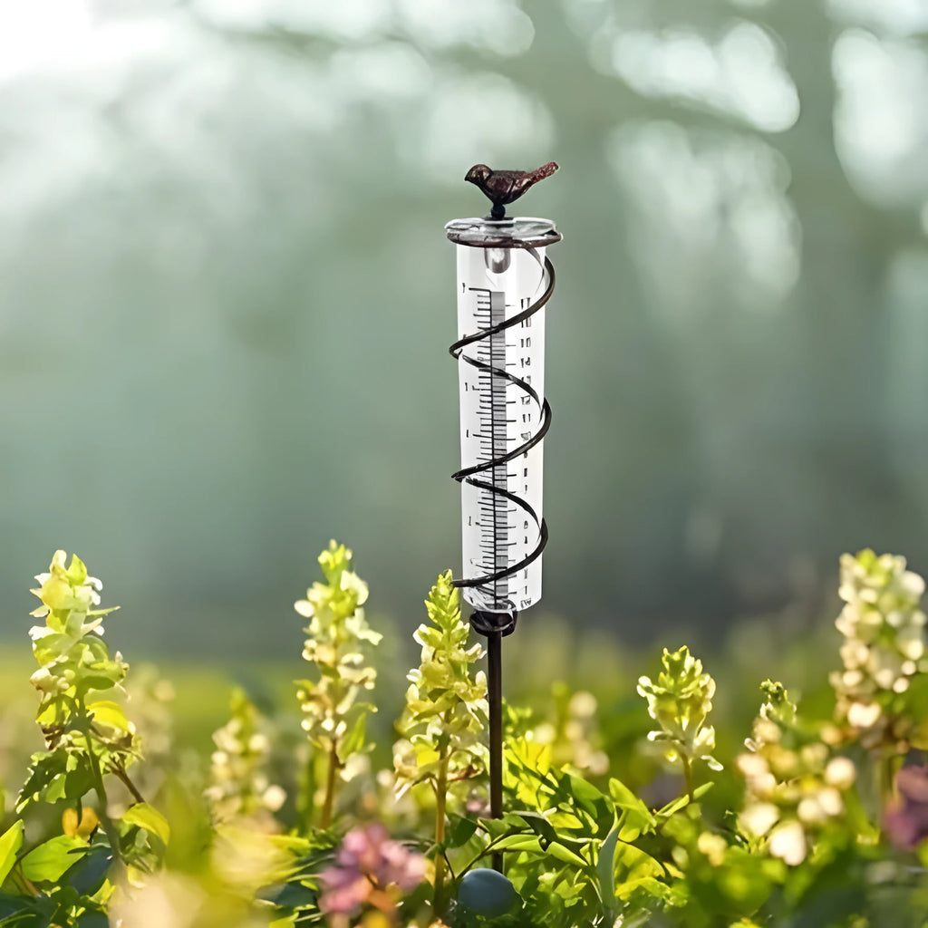 Cast iron bird-shaped rain gauge with glass measurement tube showing 1-20 scale and 800ml capacity
