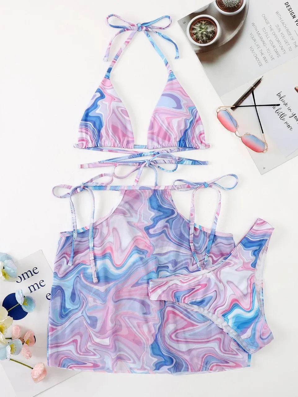 Lavender 3-piece women's bikini set with sheer beach skirt on display