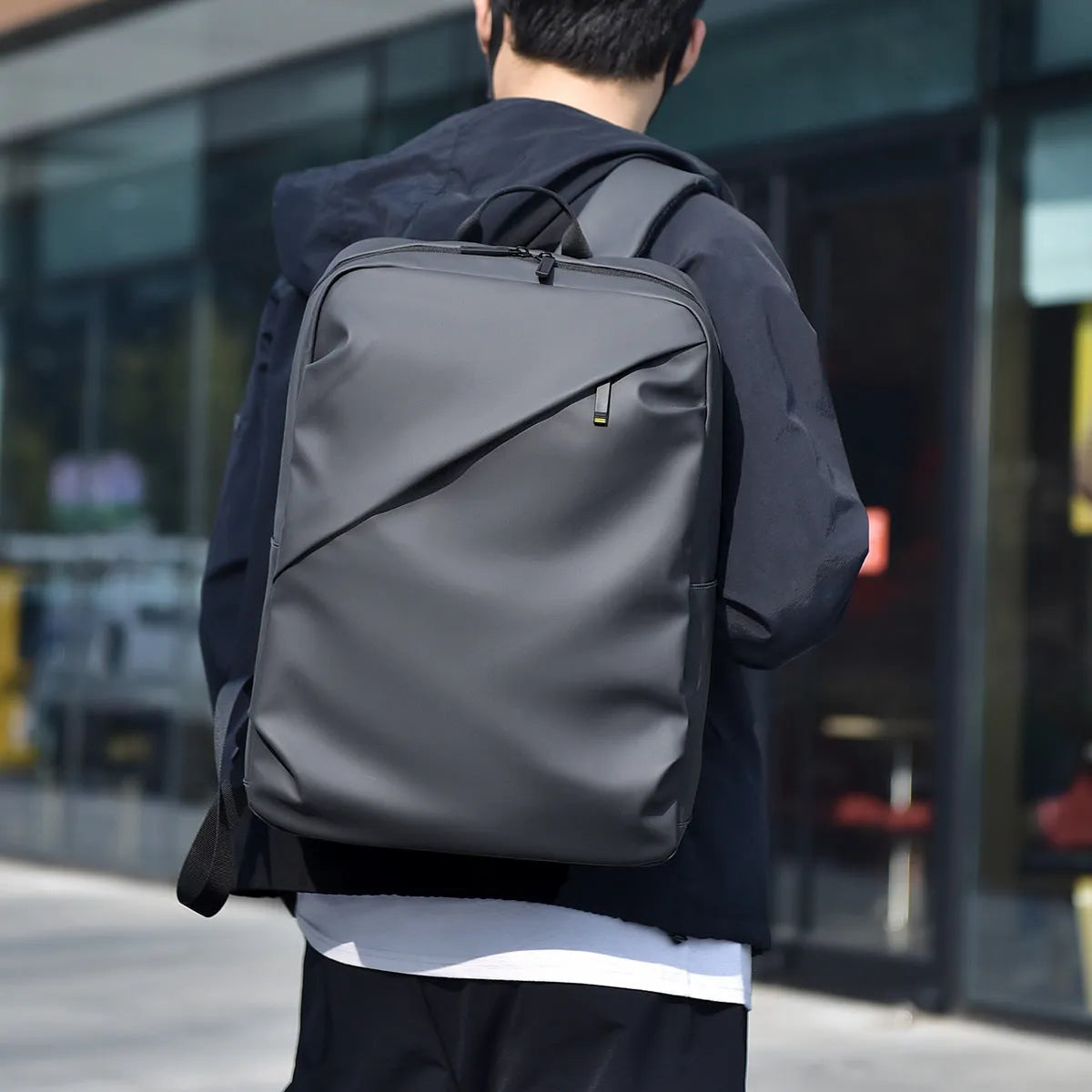 Large black waterproof backpack made from PU leather with sewing thread detailing