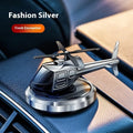 Silver metal solar-powered helicopter car air freshener rotating on a dashboard