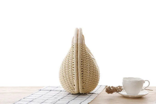 Women's round woven paper rope handbag in beige with hard shell, cover closure, and hard handle