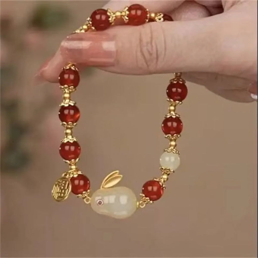 Manual crafted glass and coloured glaze bracelet with rabbit charm and silver peace buckle clasp on wrist.