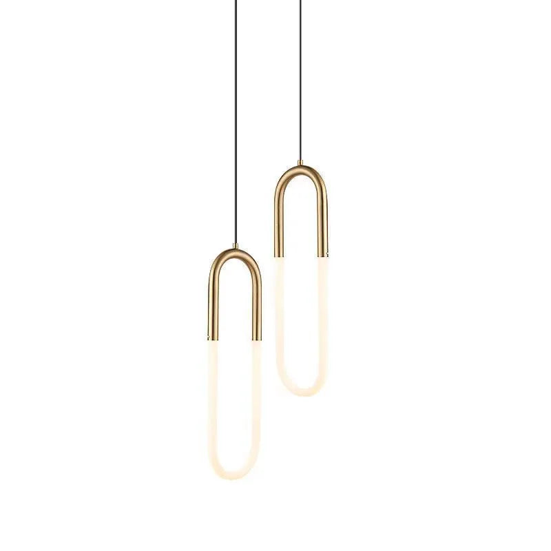 Modern Nordic-style U-shaped metal pendant light with a long black cable, hung above a bedside table.
