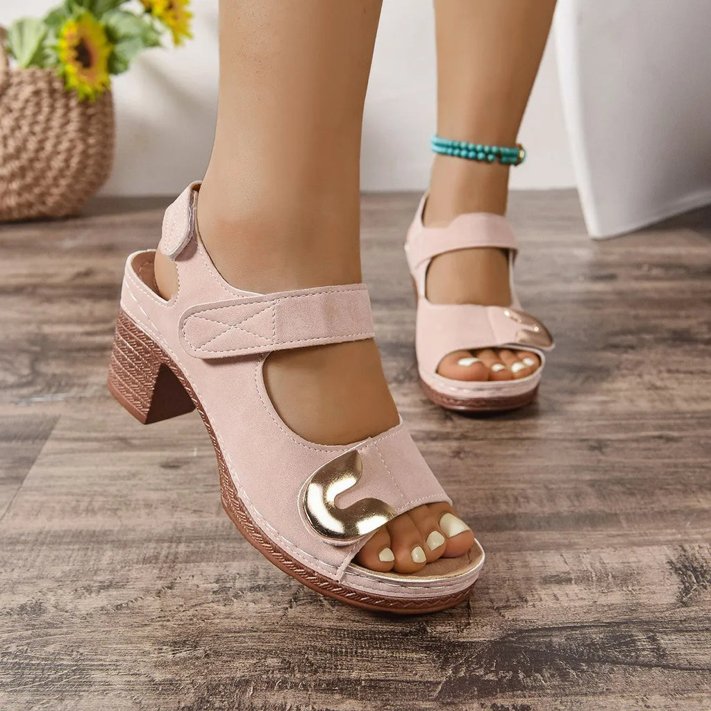 A pair of light brown Roman-style sandals with a round toe and a single adjustable Velcro strap across the instep.