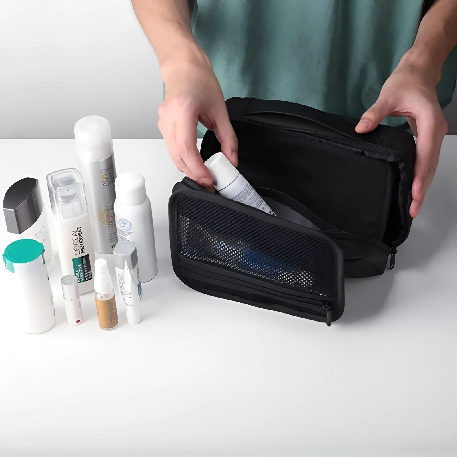 Black Oxford cloth toiletries bag with multiple compartments open, showing wet-dry separation design.