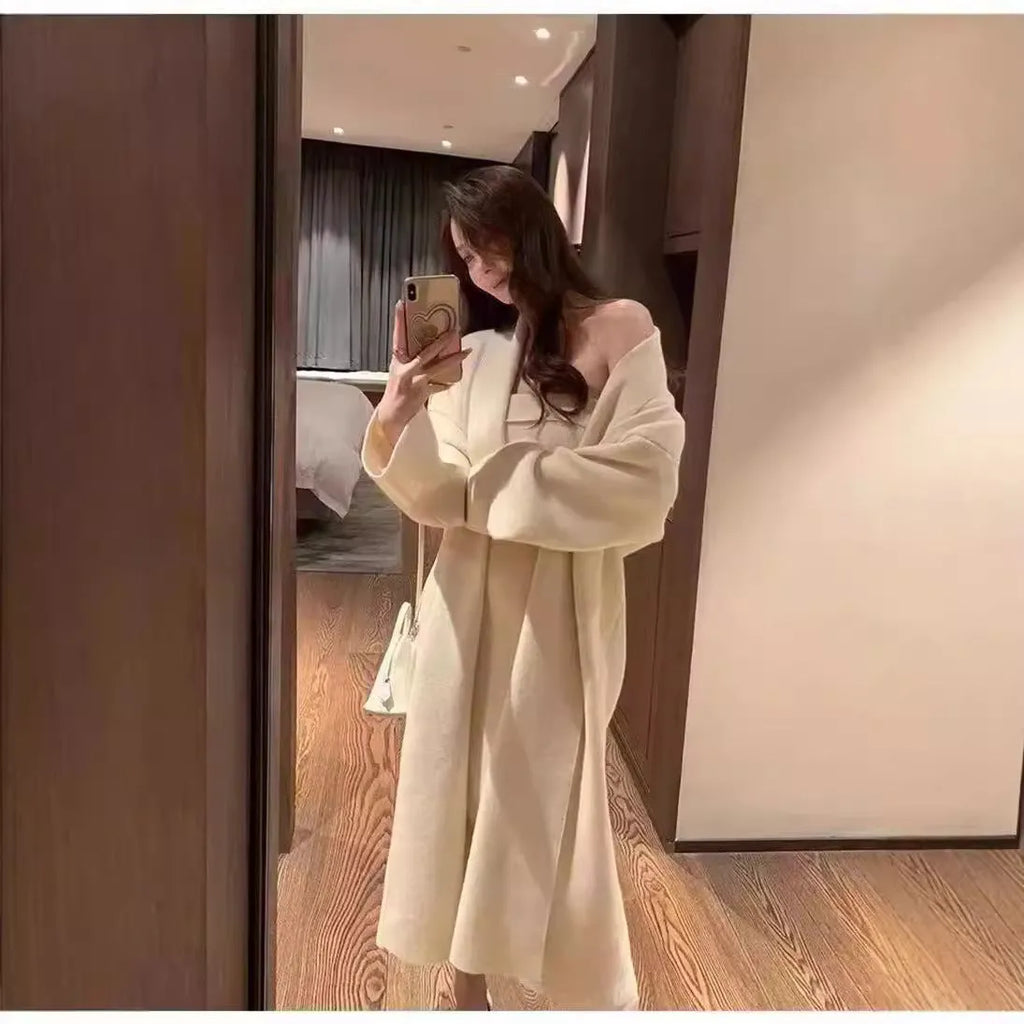 Woman wearing a grey knitted cardigan over a matching long dress with a flocked texture detail.