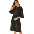 A woman's solid-colour A-line dress with long sleeves, elastic cuffs, an elastic waist, and a cinched belt.