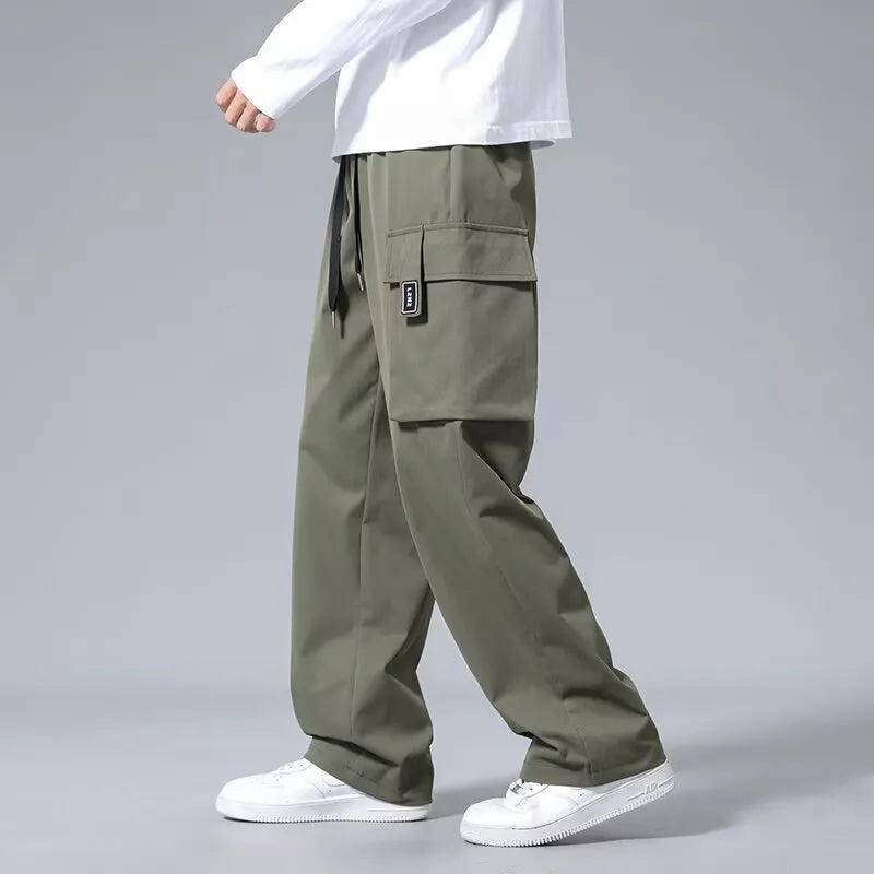 Boys' straight-leg cargo trousers in army green with large pockets and a drawstring waistband.