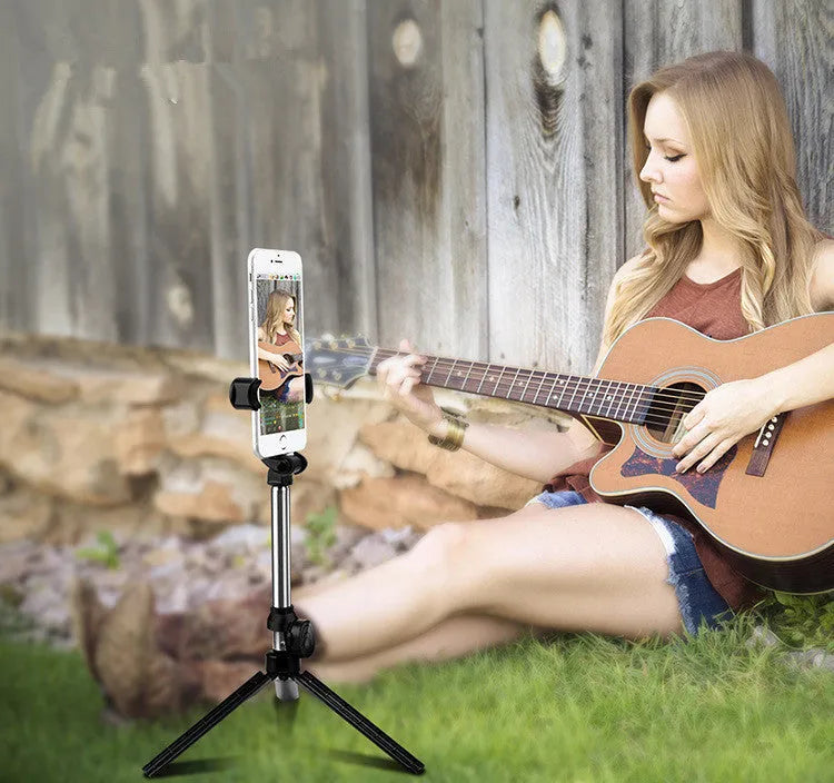 Compact black aluminium Bluetooth selfie stick with integrated tripod legs and a 360-degree rotating phone clip.