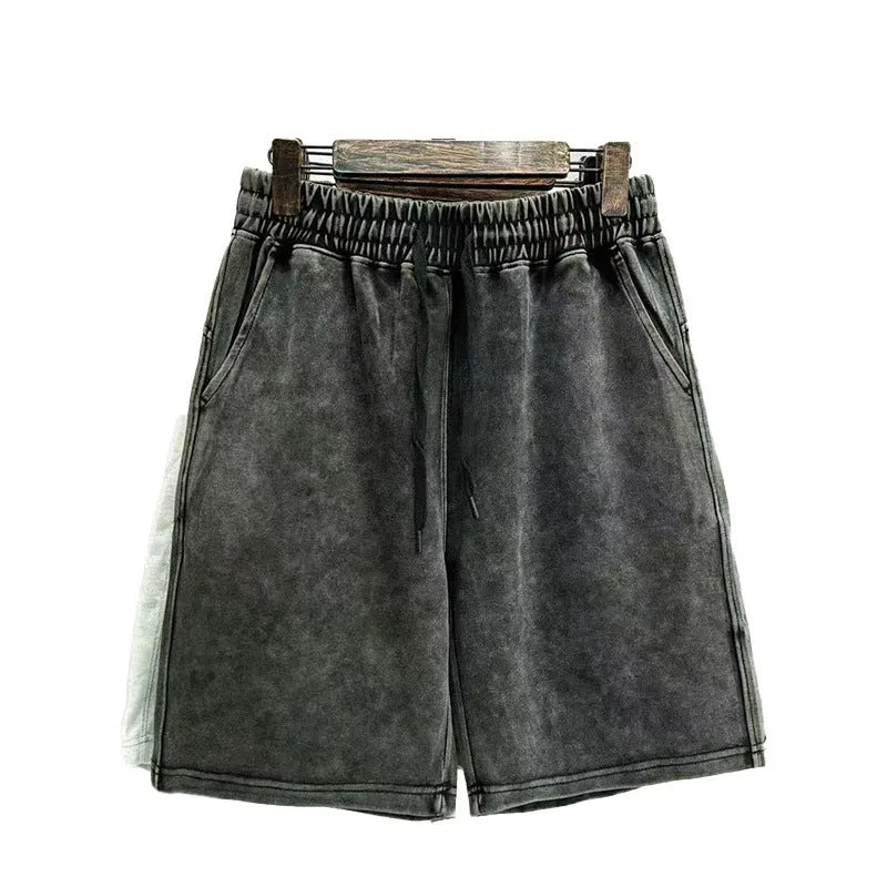 Man wearing loose-fit distressed cotton shorts in a solid colour.