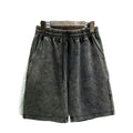 Man wearing loose-fit distressed cotton shorts in a solid colour.