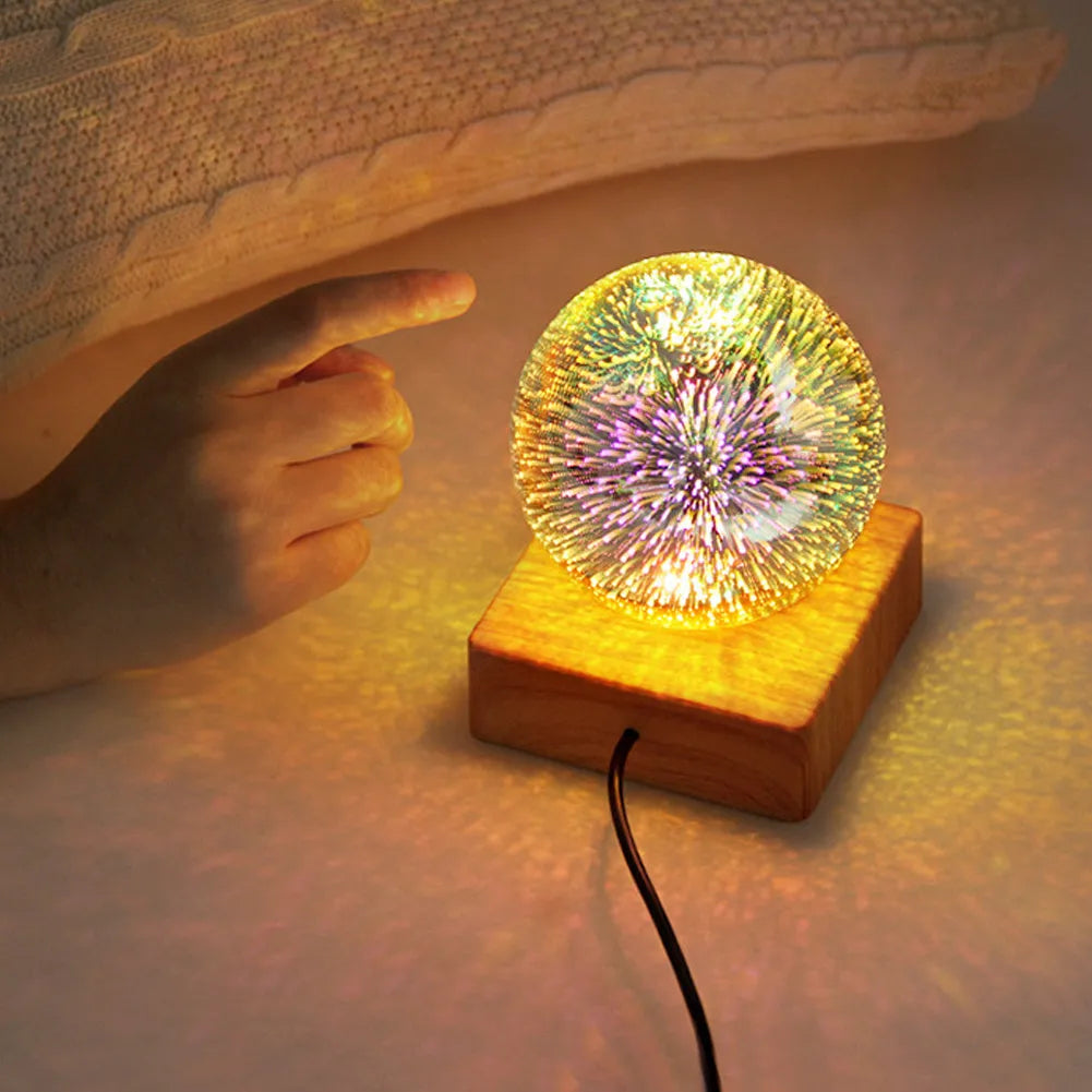 USB plug-in crystal ball LED night light showing fireworks design on a desk
