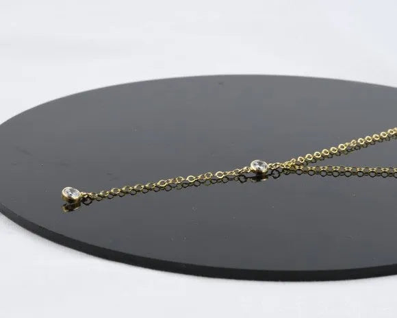 Gold alloy snake bone chain necklace with geometric pendant on display