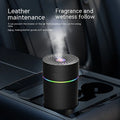 Small black and white car USB humidifier with aromatherapy function on a car dashboard.