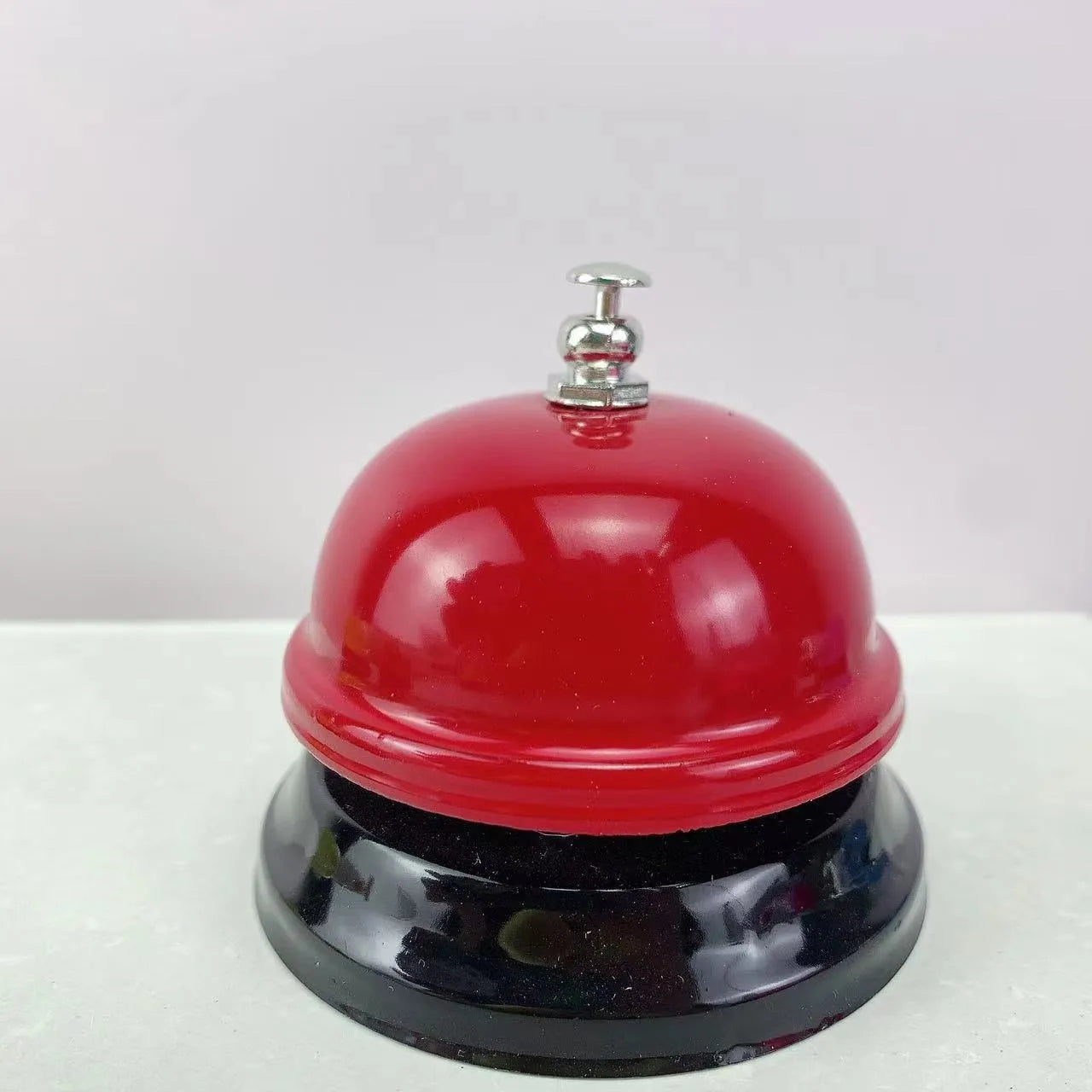 Iron game bell in assorted colours including red, blue, green, pink, and yellow for service or classroom use.