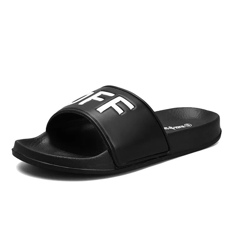 Large men's black and white open toe slippers with rubber soles on a plain background.