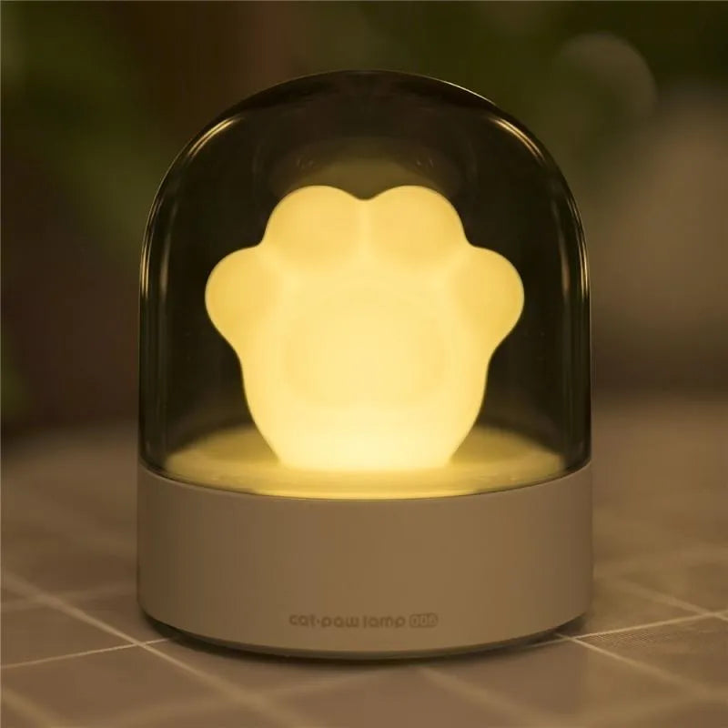 Grey and pink cat paw shaped USB rechargeable night light with rotating dynamic lighting