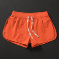 Men's loose-fit polyester beach shorts in orange, fluorescent green, and black on a size chart background.