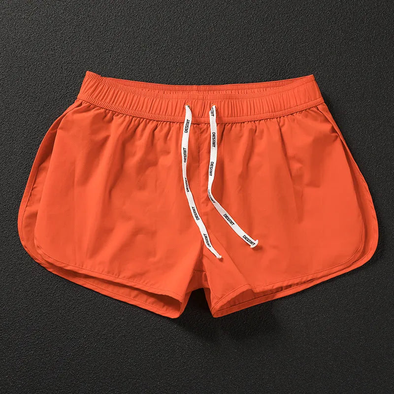 Men's loose-fit polyester beach shorts in orange, fluorescent green, and black on a size chart background.