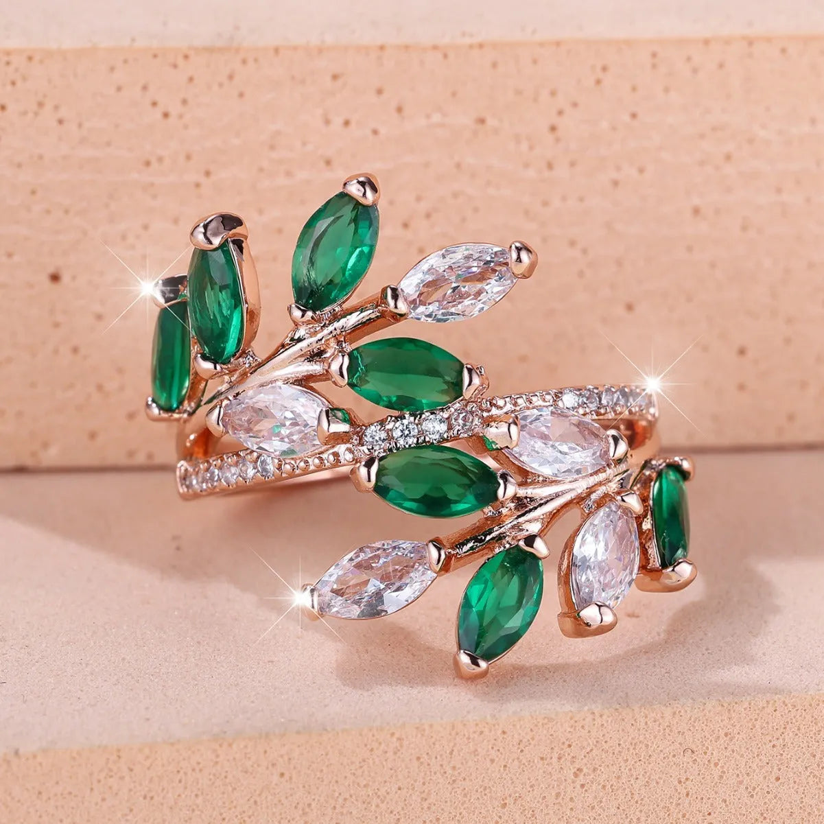 Adjustable copper leaf ring with a central zircon stone on a finger, showing rose gold and platinum colour options.