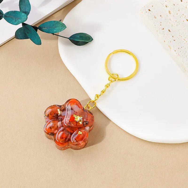 Hand-finished natural crystal cat's paw keychain pendant on a metal ring, showing detailed carving and polished stone surface.