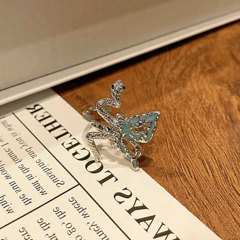 Creative butterfly design women's ring in copper with oil drip finish, showing an open loop style.